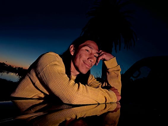 Image shows a man taking a picture at night, showcasing the Night Sight camera feature